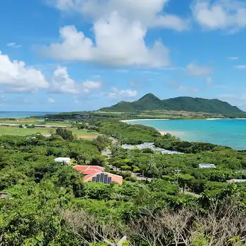 Panoramic view from Tamatorizaki observation platform, Ishigaki Island — turquoise bay, green hills, and blue sky